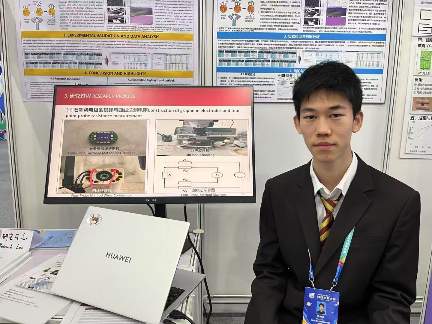 Tenne beside a research display at a competition